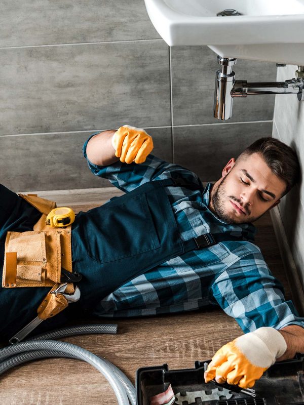 bearded handyman lying on floor near toolbox